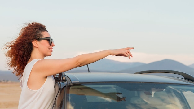 Foto grátis mulher na janela do carro apontando