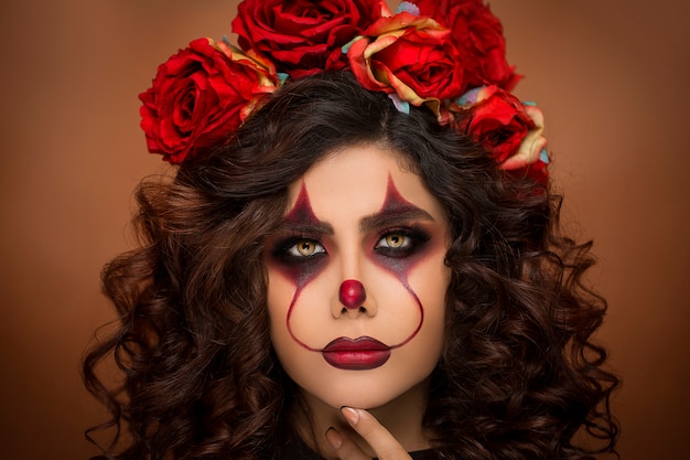 Mulher na maquiagem de diabo halloween com miçangas de flores