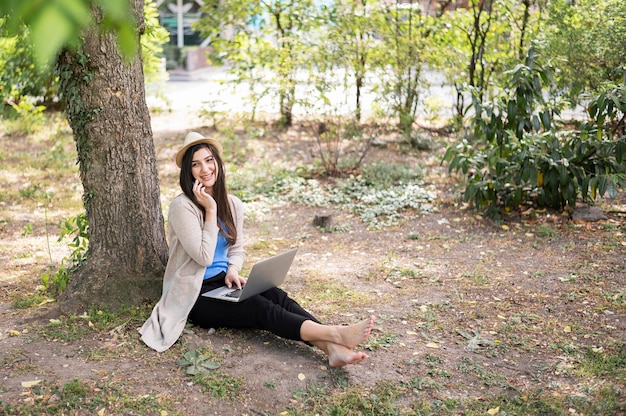 Mulher na natureza trabalhando no laptop