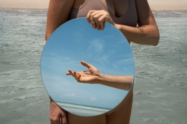 Foto grátis mulher na praia no verão posando com espelho redondo