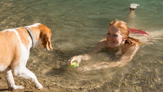 Foto grátis mulher nadando e brincando com o cachorro