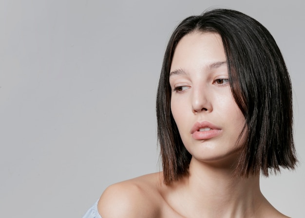 Mulher natural posando enquanto olhando para longe e copie o espaço