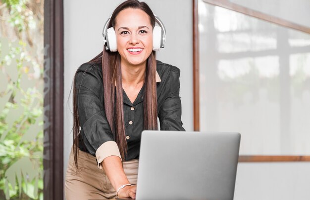 Mulher negócio, com, fones, olhando câmera