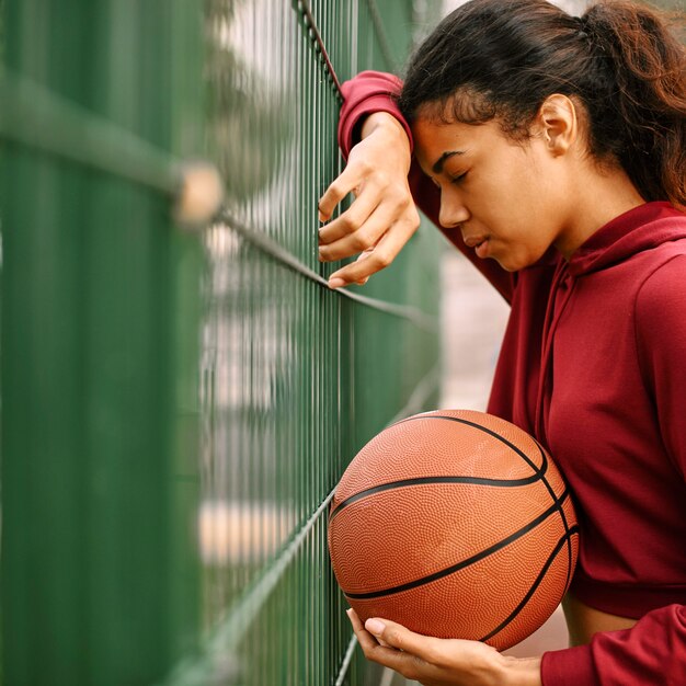 Mulher negra americana jogando basquete com espaço de cópia