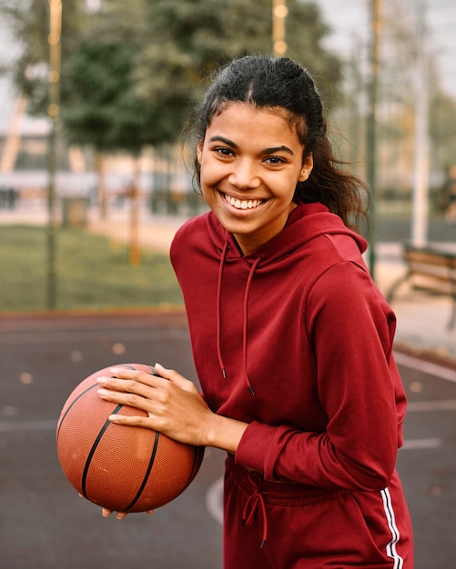 Mulher negra americana segurando uma bola de basquete