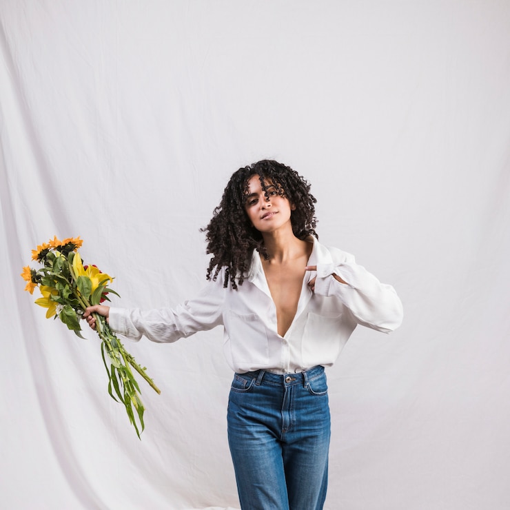 Foto grátis mulher negra bonita que guarda o ramalhete das flores