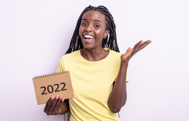Mulher negra bonita se sentindo feliz, surpresa ao perceber uma solução ou ideia. conceito de calendário 2022