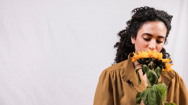 Foto grátis mulher negra, cheirando a flor