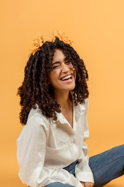 Mulher negra com flores no cabelo a rir