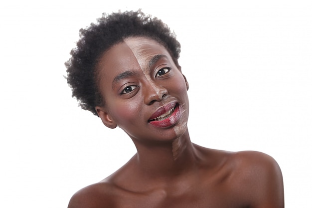 Mulher negra com metade do rosto na maquiagem, conceito de beleza