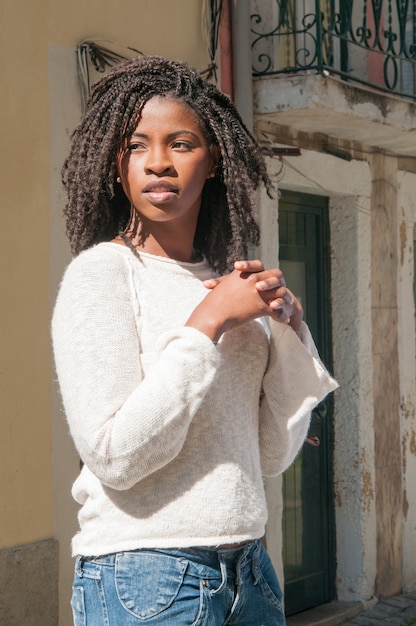 Foto grátis mulher negra consideravelmente nova pensativa que está ao ar livre