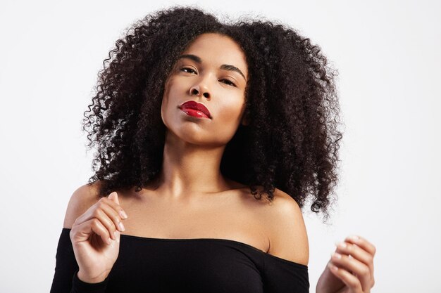 Mulher negra dançando com cabelo afro em sessão de estúdio