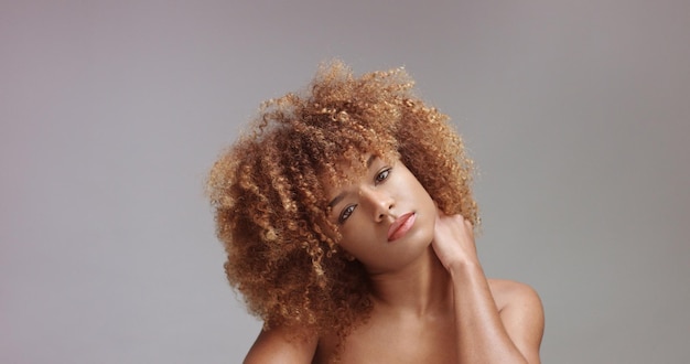 Mulher negra de raça mista com retrato de maquiagem neutra cabelo encaracolado ideal pele estúdio fundo cinza