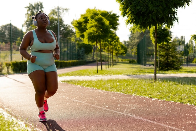 Foto grátis mulher negra de tiro completo treinando ao ar livre