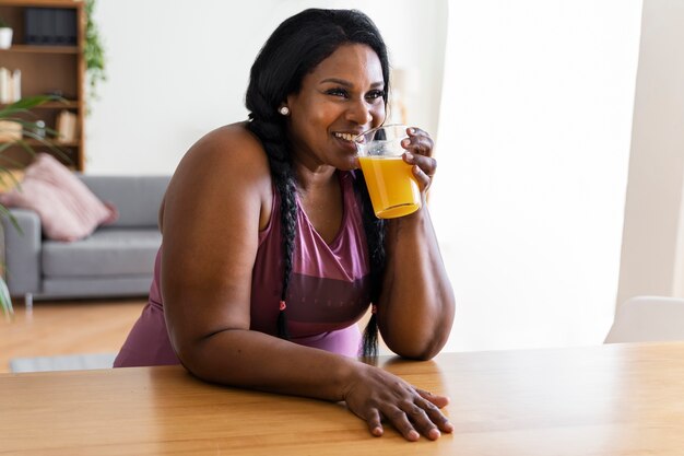 Mulher negra de tiro médio relaxando em casa