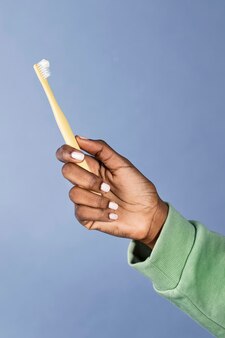 Mulher negra segurando uma escova de dentes