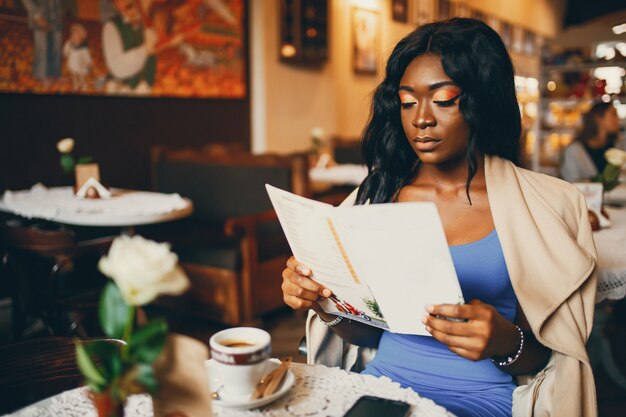 Mulher negra sentada em um café