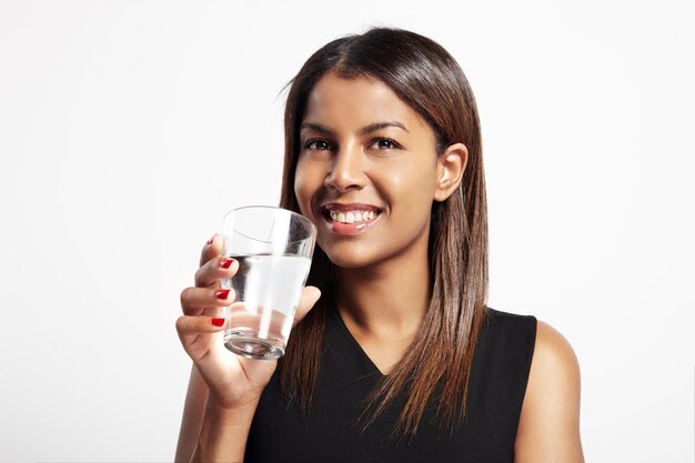 Mulher negra sorridente bebendo água