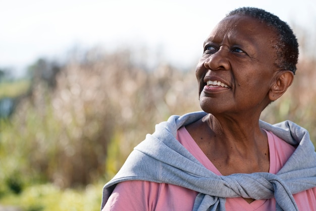 Foto grátis mulher negra sorridente de tiro médio ao ar livre