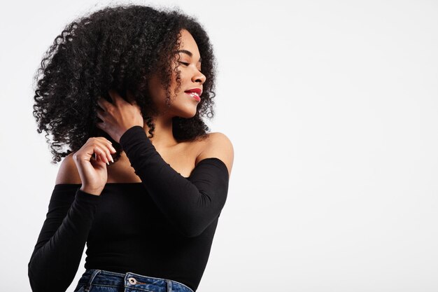 Mulher negra tocando seu cabelo encaracolado