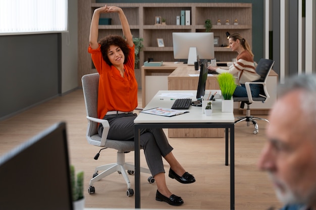 Mulher no escritório se alongando durante um dia de trabalho