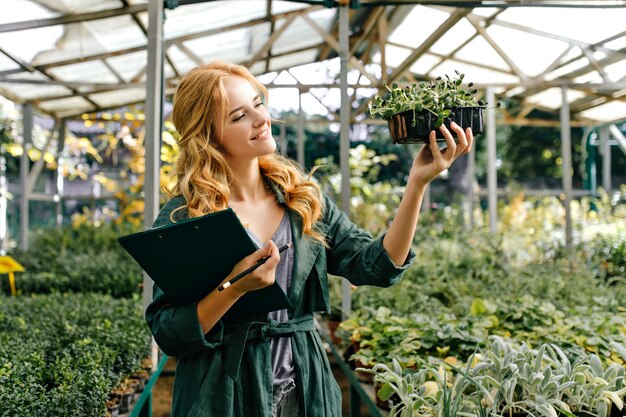 Mulher no jardim botânico, com grande número de diferentes plantas vivas