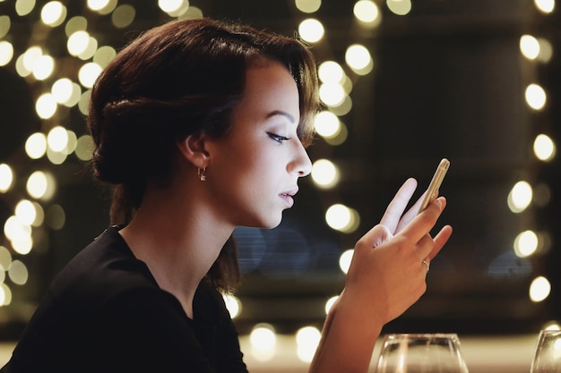 Mulher no restaurante usando o smartphone