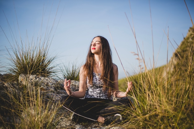 Mulher no rock fazendo meditação