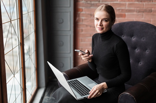 Foto grátis mulher no sofá com o laptop e celular