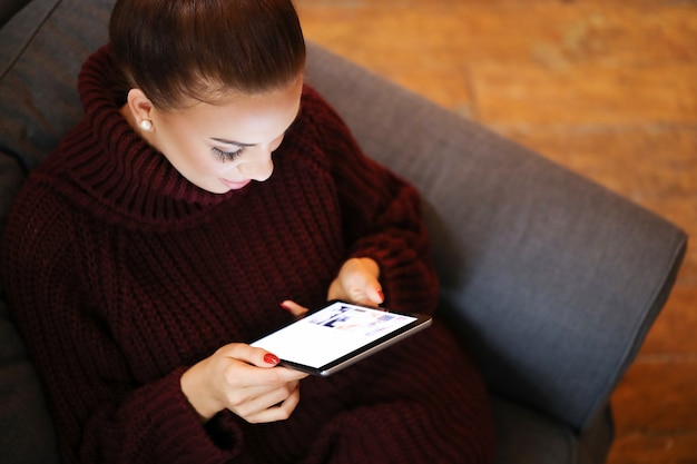 Mulher no sofá com um tablet