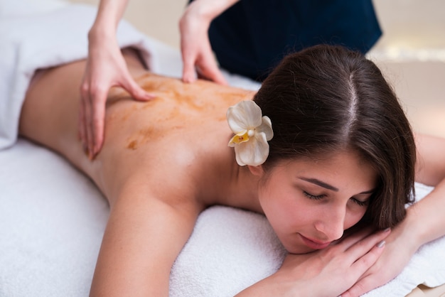 Mulher no spa, desfrutando de uma massagem nas costas