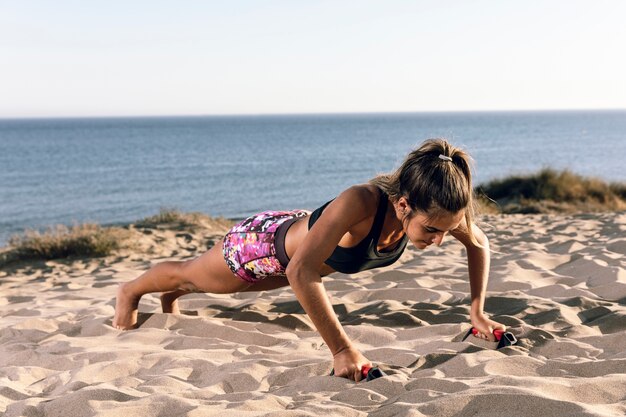 Mulher no sportswear fazendo flexões