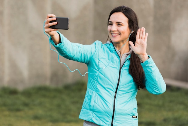 Mulher no sportswear tomando uma selfie lá fora