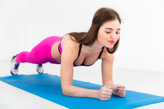 Mulher no tapete fazendo exercício de resistência