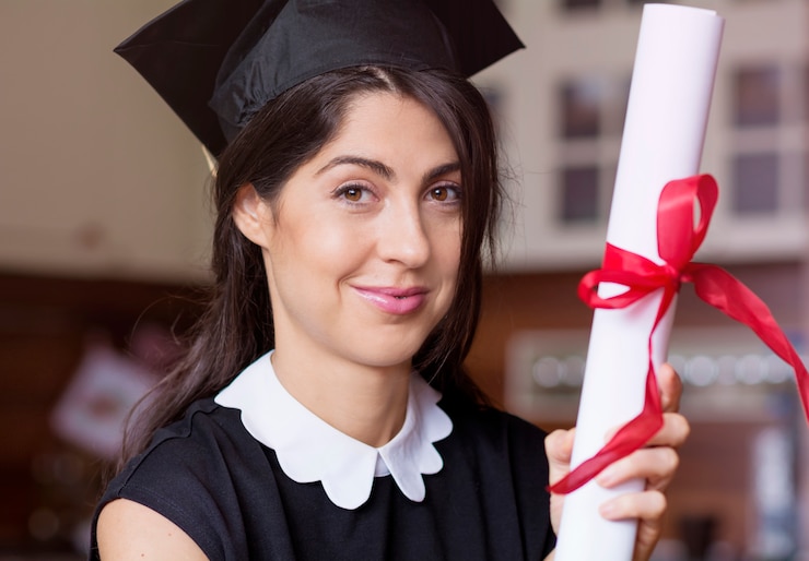 Foto grátis mulher nova bem sucedida que levanta com seu diploma