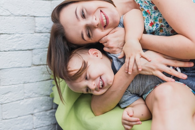 Mulher nova feliz que joga com seu filho