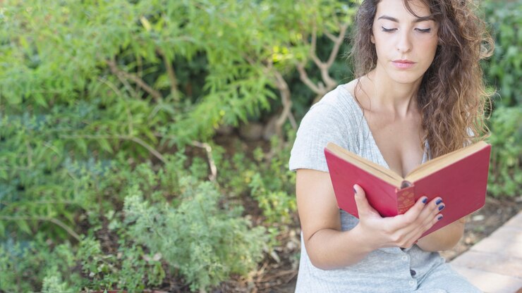 Foto grátis mulher nova que lê um livro