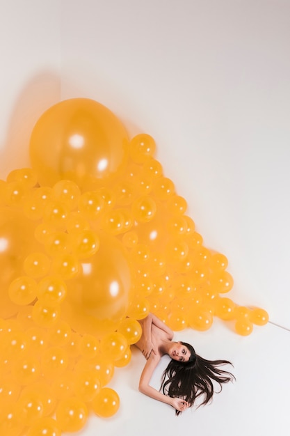 Foto grátis mulher nua entre muitos balões amarelos
