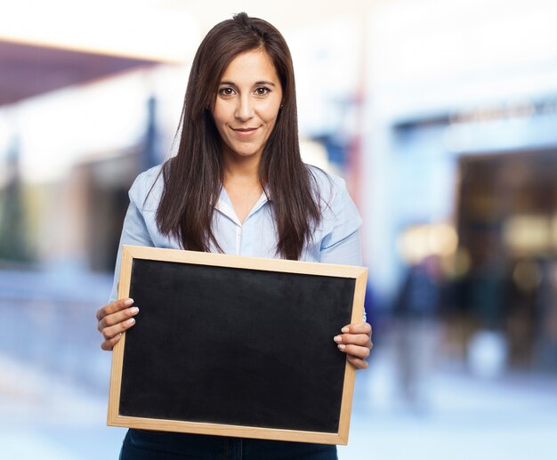 Mulher ocasional com um quadro-negro nas mãos