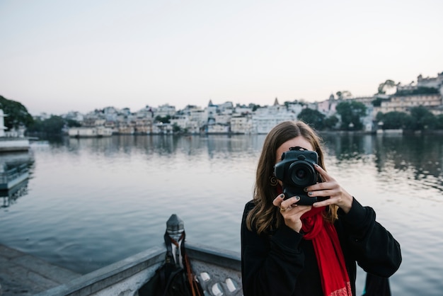 Foto grátis mulher ocidental, capturando uma vista da cidade de udaipur, índia