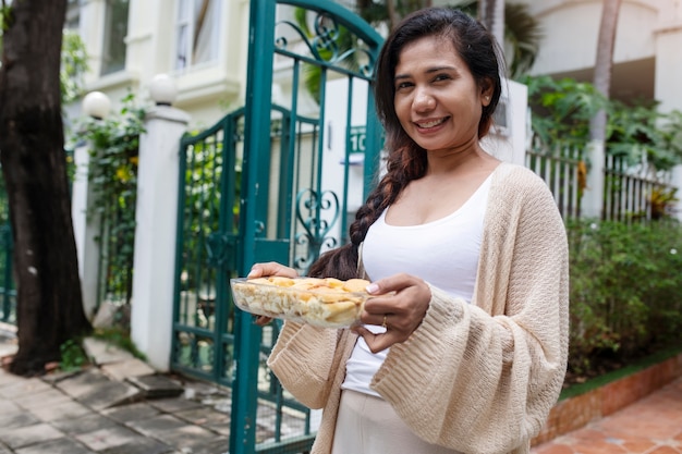 Mulher oferecendo comida ao vizinho