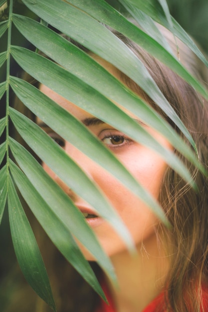 Foto grátis mulher olha, câmera, através, folhas