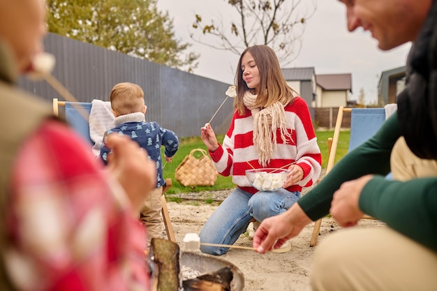 Foto grátis mulher olhando com prazer marshmallows na vara