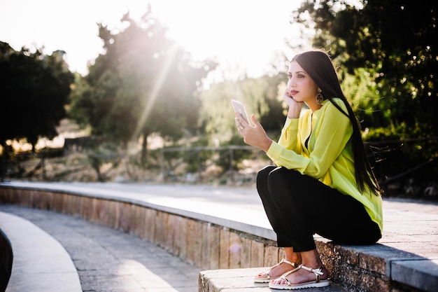 Foto grátis mulher olhando o smartphone nos passos