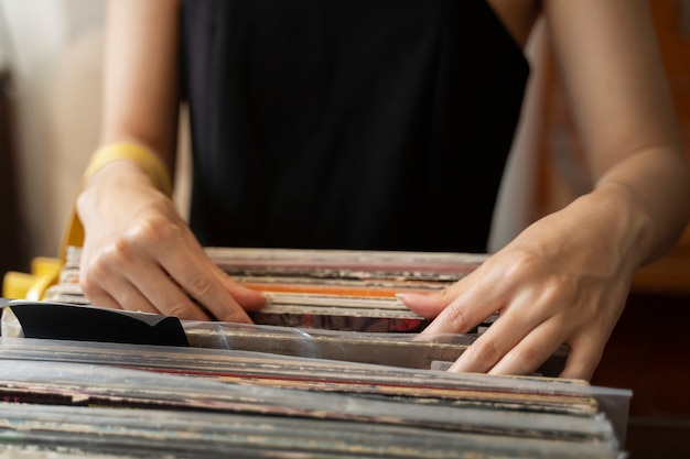 Mulher olhando para a vista frontal de discos de vinil