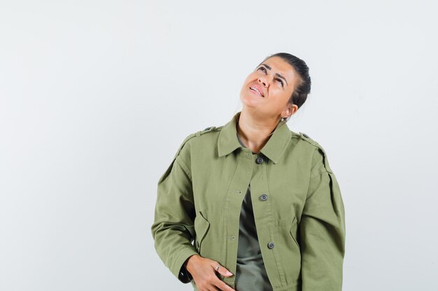 mulher olhando para cima em jaqueta, camiseta e parecendo focada