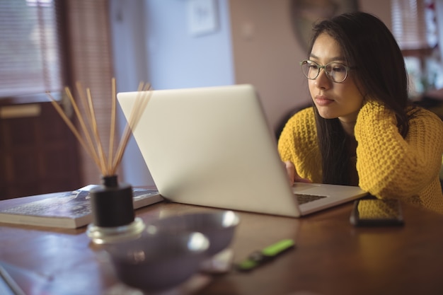 Mulher olhando para o laptop na mesa