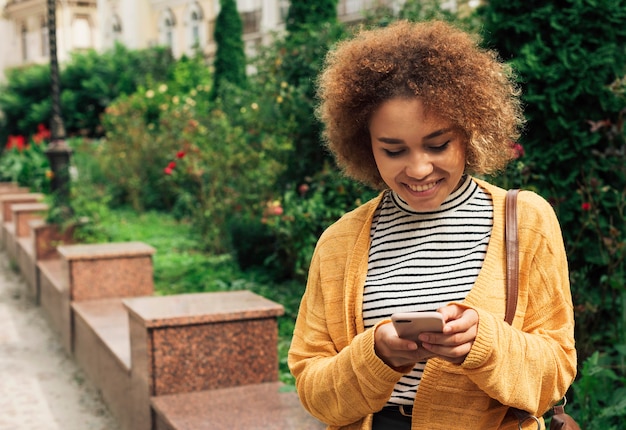 Foto grátis mulher olhando para o telefone no outono