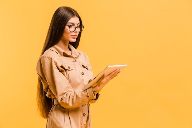 Foto grátis mulher olhando para tablet no estúdio