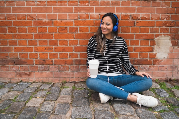 Mulher ouvindo música com uma xícara de café.